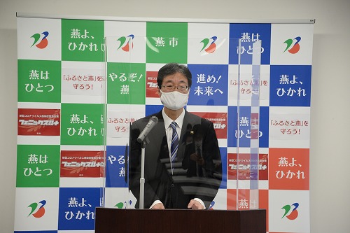パネルの前に立つ燕市長