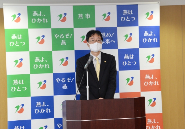 パネルの前に立つ燕市長