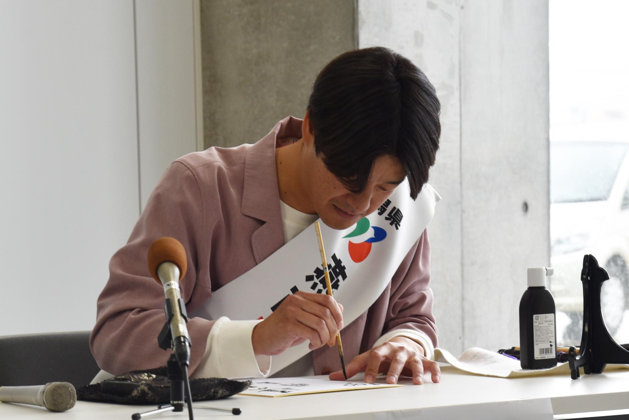 色紙に公約を書く山脇さん
