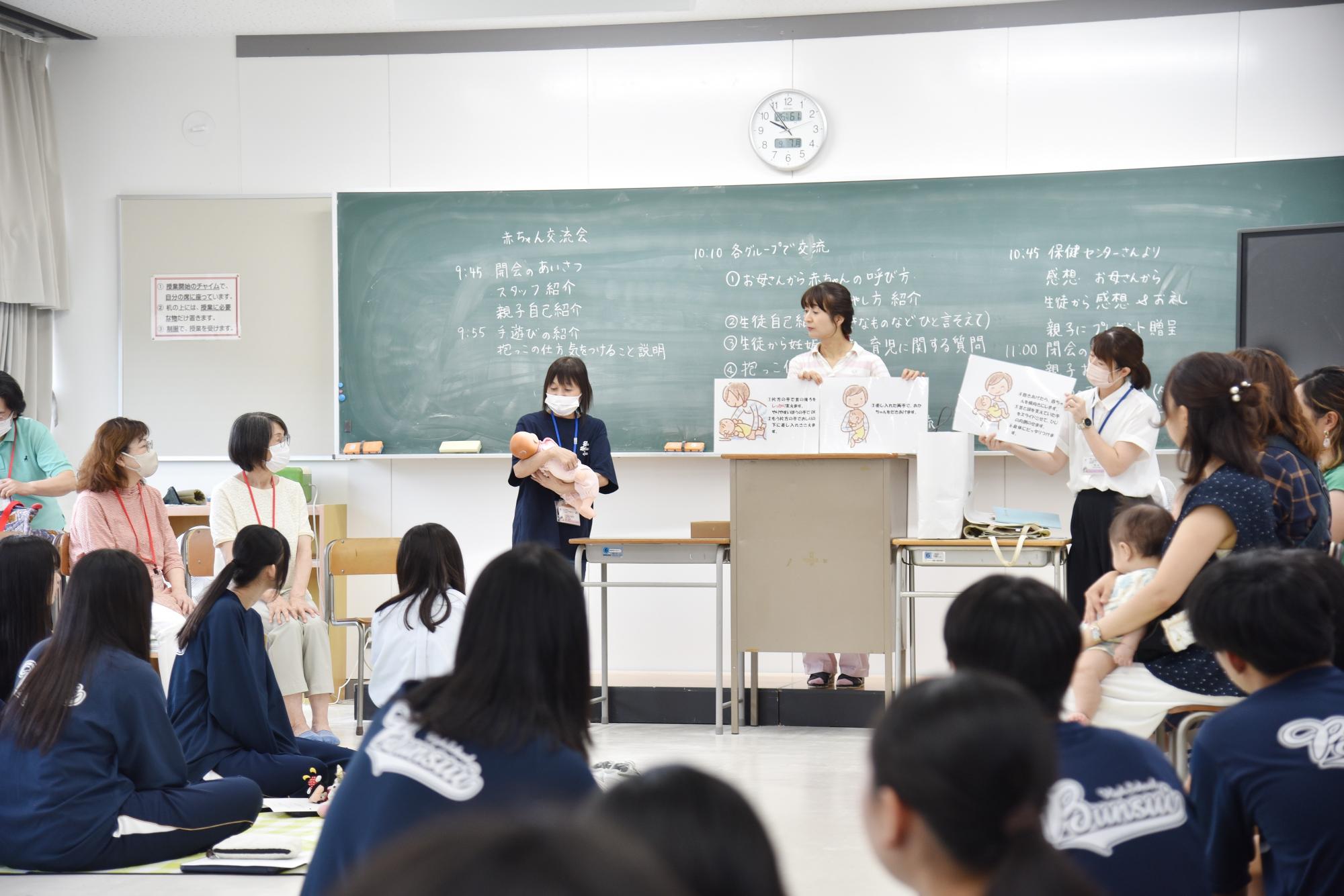 赤ちゃん交流会で抱っこの仕方を説明している様子