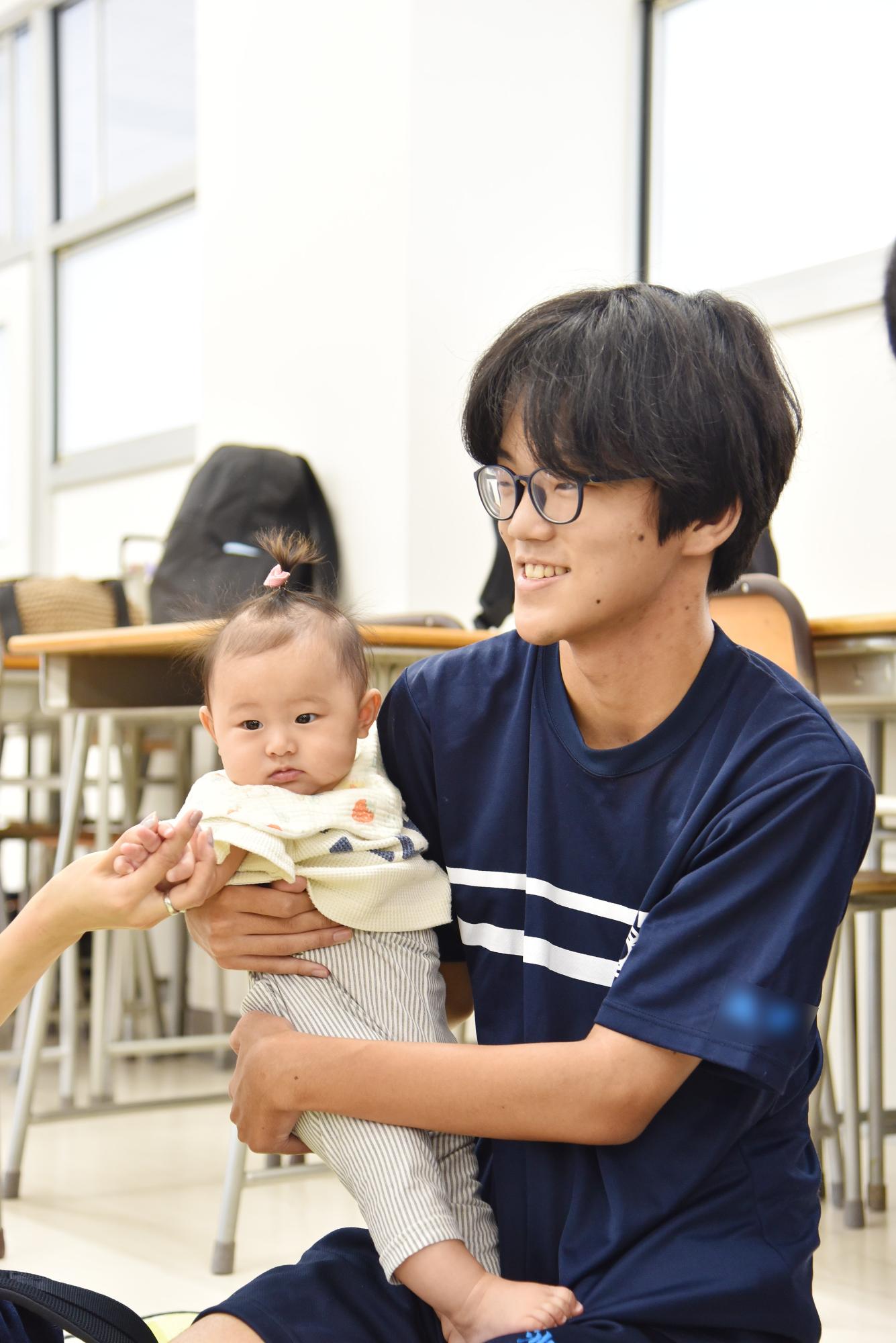 赤ちゃん交流会で高校生が赤ちゃんを抱っこしている様子