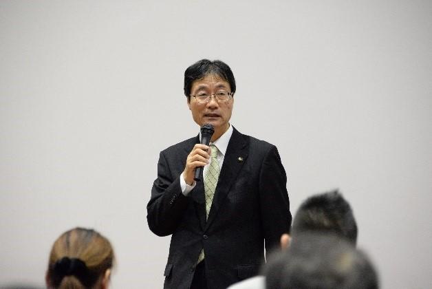 大勢の高齢者の前で農福連携の取り組みについて公演する燕市長の写真