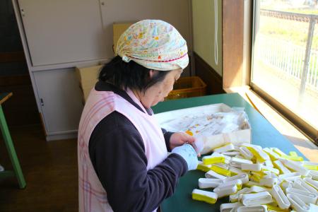 女性が製品を袋詰めしている写真