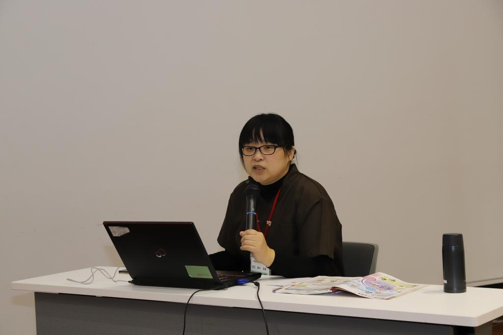 介護食体験講座・在宅療養の出前講座で椅子に座ってマイクを使い説明をする眼鏡をかけた女性の写真