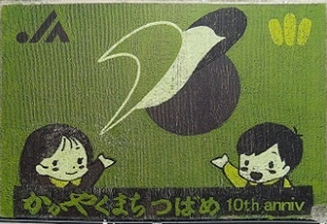 かがやくまちのつばめ10th annivと書かれ女の子と男の子が手を挙げている先につばめの絵が描かれている田んぼアートの写真