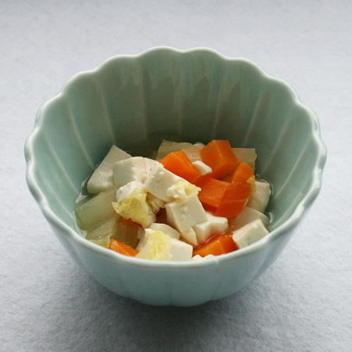 緑の器ににんじんと白菜が入った豆腐の煮やっこの写真