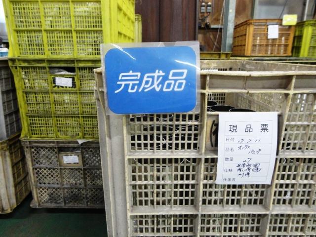 多数の箱が置かれている場所で完成品と書かれた名札が白い箱に付いている写真