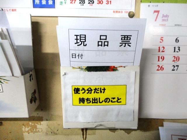 壁に現品票と書かれたトレイがカレンダーの横に付けられている写真