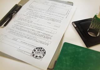 たくさんの文字が書かれた用紙の右にスタンプと下敷きが置いてある写真