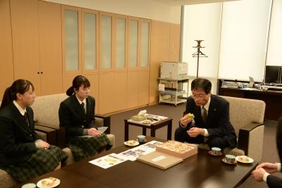 2人の女子生徒と1人の男性がカステラを実食している写真