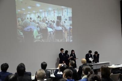 スクリーンに映った映像に合わせて5人の高校生が話をしている写真