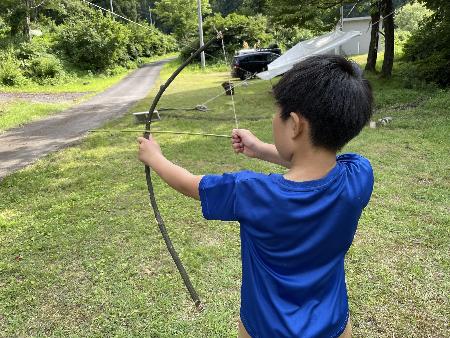 長善館学習塾の塾生がキャンプで弓矢で遊んでいる様子