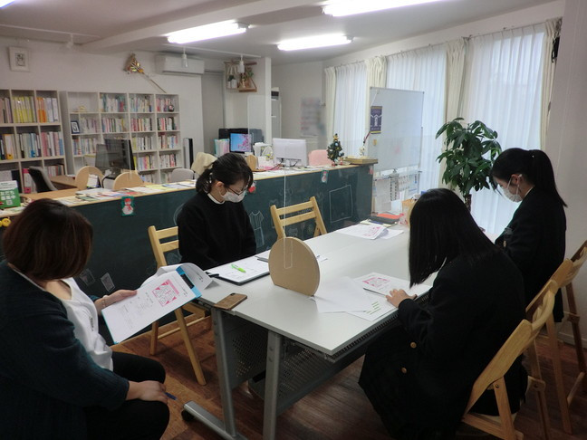 生徒2人が実習先の企業の人に調査結果を説明している写真