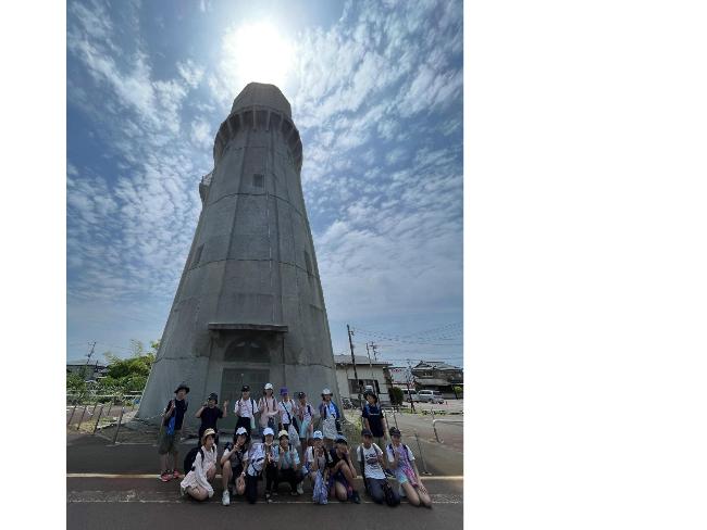 水道の塔の前で集合写真を撮る塾生たち