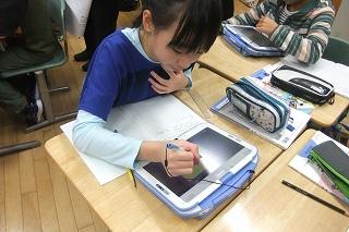 端末にペンの形をした入力機器で描き込みをしている児童の写真