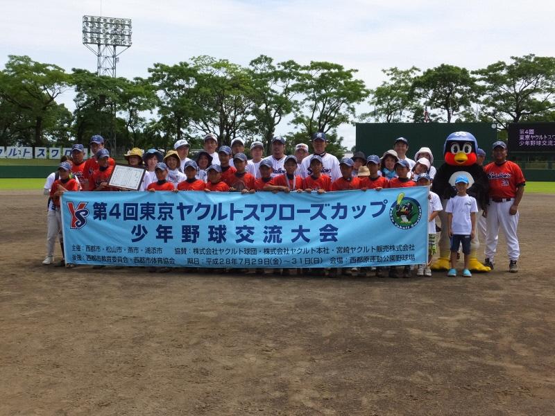 ユニフォームを着た児童たちがグラウンドで記念撮影をしている写真