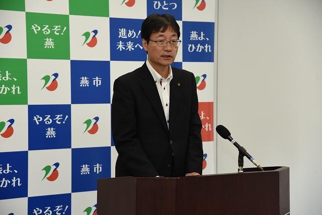 スーツ姿で演台に立つ市長の写真