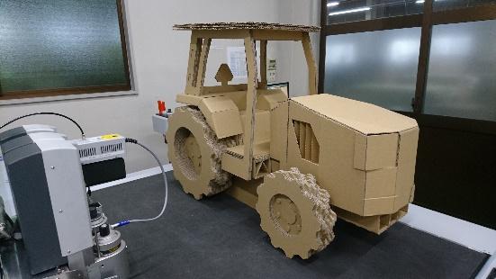ダンボール製のトラクターを斜め前方から撮影した写真