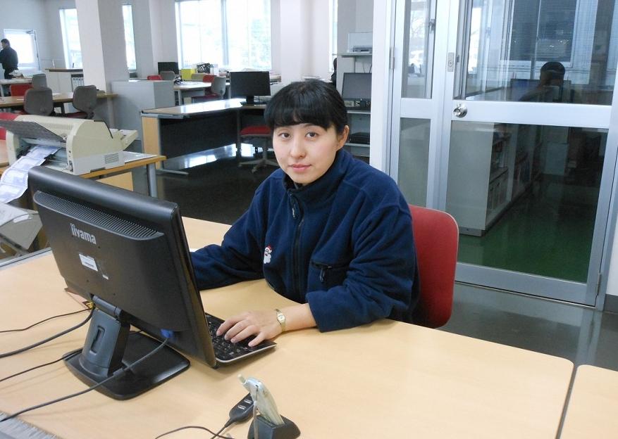 パソコンのある部屋で女性がデスクに向かっている写真
