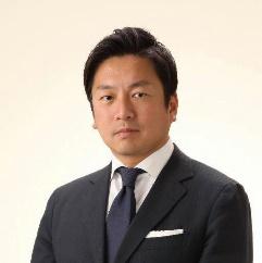 黒いスーツに身を包んだ留目真伸氏の写真