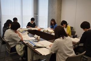 室内で資料を見つめる人たちの写真