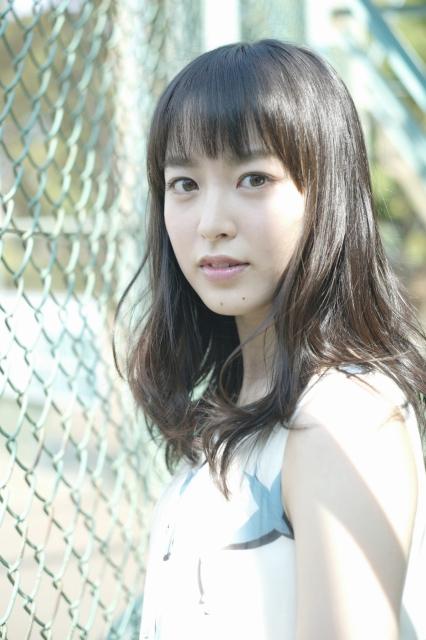 暗い髪の若い女性がこちらを向いている写真