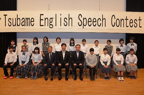 横2列に並んで座り記念撮影をする人たちの写真