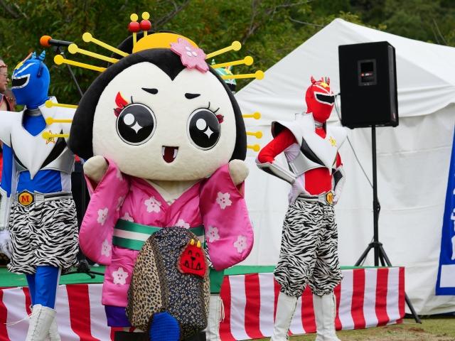 マスコットキャラクターが舞台に立ちパフォーマンスしている写真