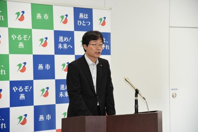 スーツを着て演台に立ち話す市長の写真