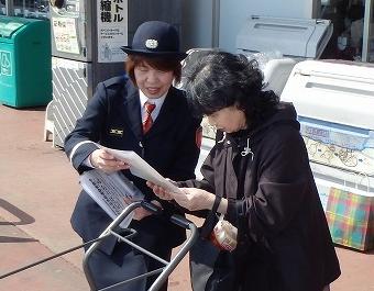 女性の警官が、高齢の女性に書類を見せながら話をしている写真