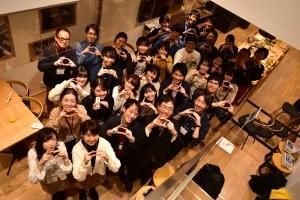 カメラに向かってポーズをとり記念撮影する人たちの写真