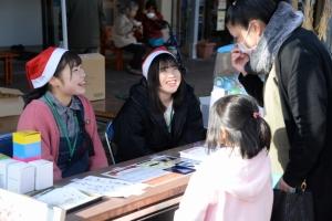 訪れた人たちに笑顔で話しかける女性の写真