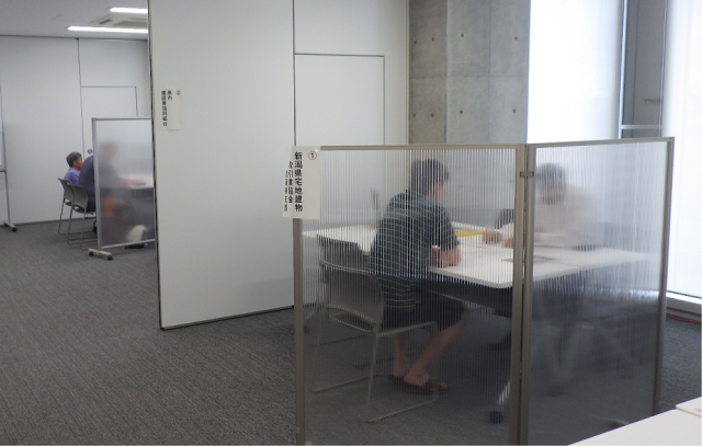 パーテーションが設置された室内で相談会が行われている写真