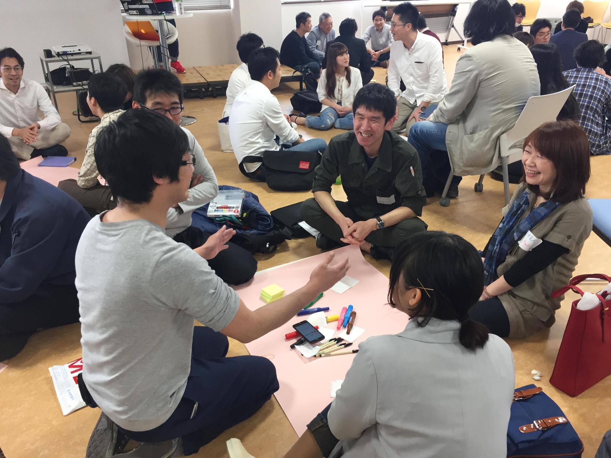 身振りを交えてコミュニケーションをとる人たちの写真