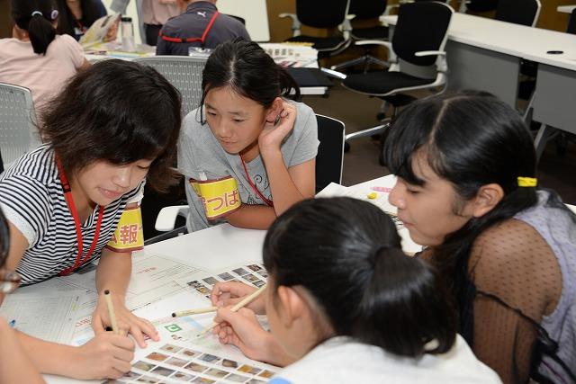 沢山の写真の中から使用する写真を選んでいる、4人の女の子のみのグループの写真
