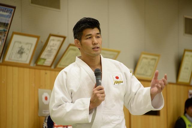 身振り手振りをしつつ話をしている井上康生選手の写真
