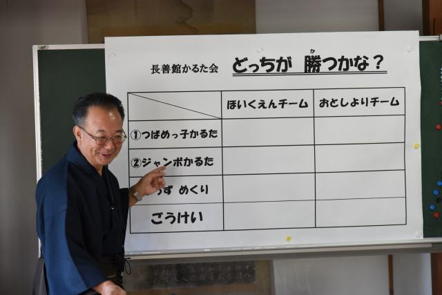 星取表を前にルールの説明をしているメガネ姿の男性の写真