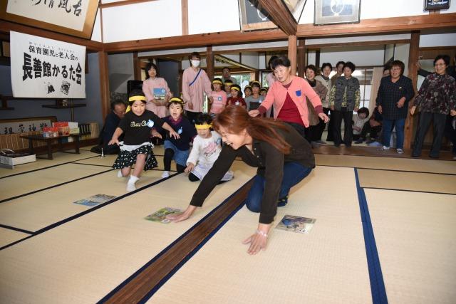 大きなかるたを一枚取った女性の写真