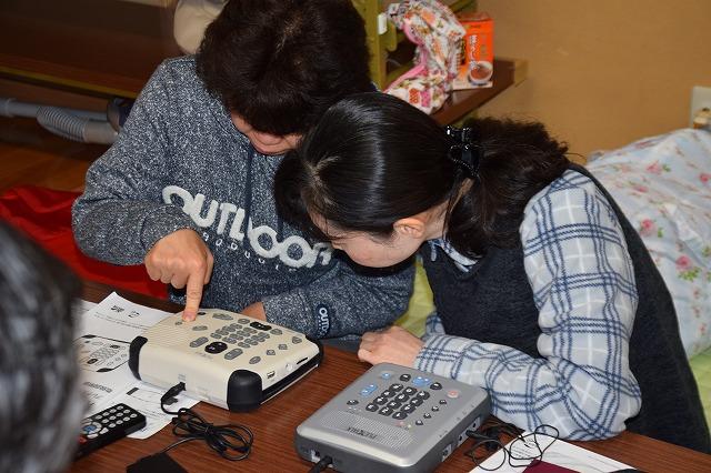 デイジー再生機の機種を触っている女性参加者とそれを覗き込んでみている女性参加者の写真