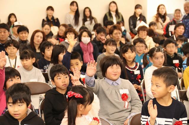 たくさんの参加者の中、元気に手を上げている子ども達の写真