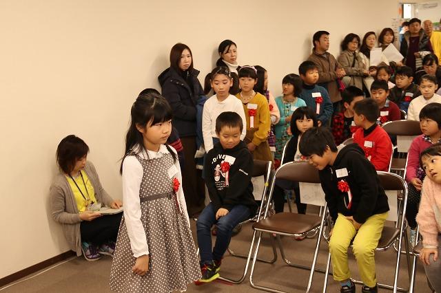 沢山の参加者の中、緊張の面持ちで立っている少女のを写した写真