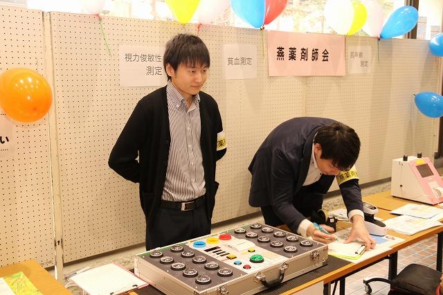 スーツ姿の男性二人が自分のブースで受付をしている様子の写真