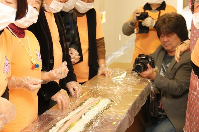 具材が乗せられたのり巻きを巻く直前の様子を真横から撮影しているカメラマンの写真