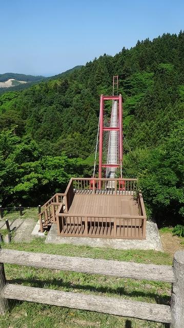 山奥に続いている赤い吊橋の様子の写真