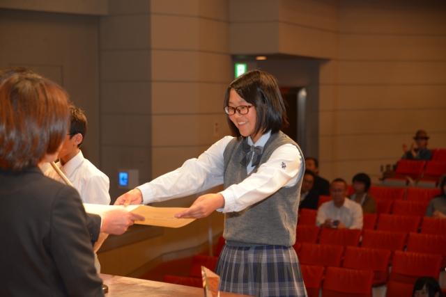 賞状を両手で受け取る制服を着たメガネ姿の女子の写真