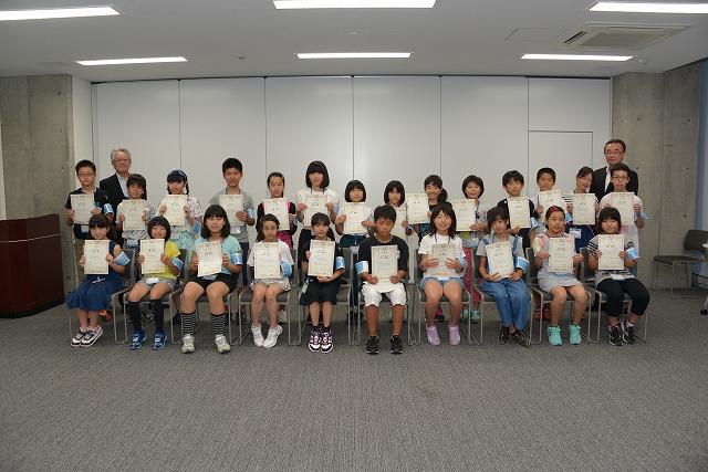 二列に並んで任命書を見せている子ども達の記念写真