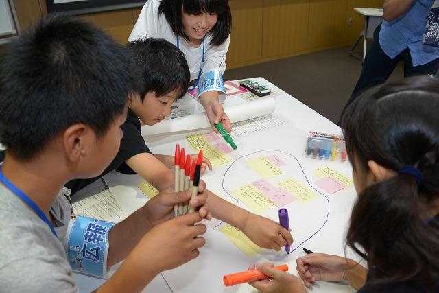 色ペンを手にわら半紙に書き込んでいく子ども達の様子の写真