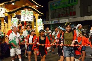 提灯を下げた山車を引っ張っている人たちの写真