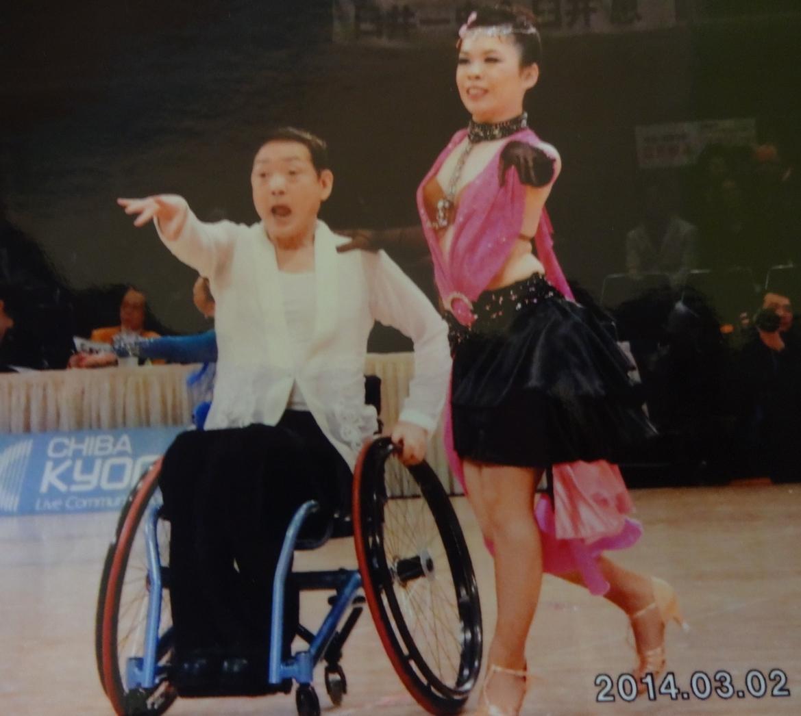車椅子に乗った女性と派手な衣装の女性の写真