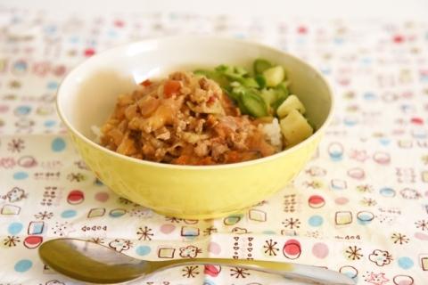 季節の野菜がトッピングされたトマみそカレー豚丼の写真